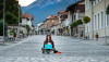 Eine Frau sitzt auf der Straße und tippt in ein Laptop