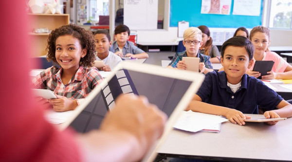 Grundschüler und -schülerinnen mit Tablets