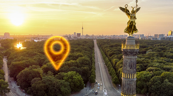 Ein Geo-Pin markiert einen Punkt auf einem Foto vom Berliner Tiergarten und der Siegessäule
