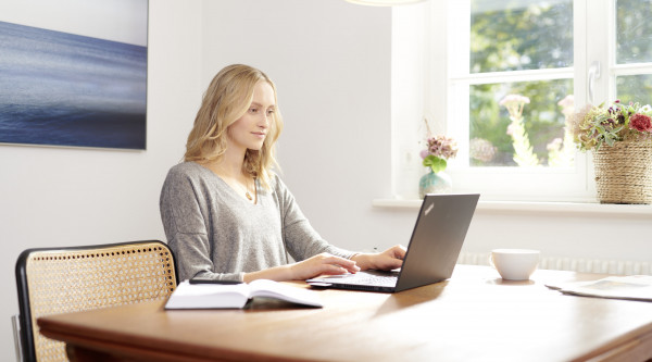 Eine Mitarbeiterin arbeitet im Homeoffice am Laptop