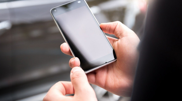 Eine Person hält ein Smartphone mit dem Android Betriebssystem in denHänden