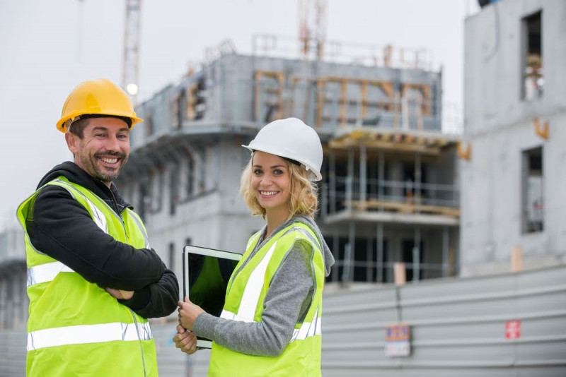 Zwei Städtebauer mit Tablet vor einer Baustelle