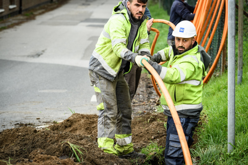 Zwei Männer verlegen Glasfaserkabel