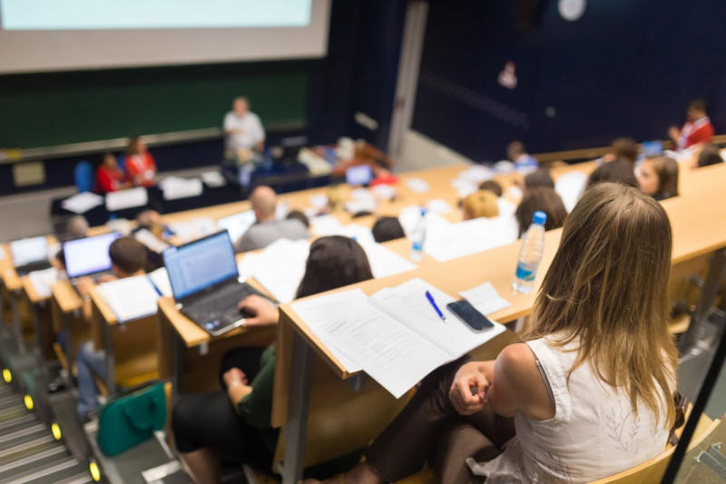 Blick in einen Hörsaal, Studierende sitzen an Pulten