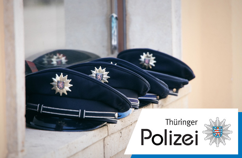 Einige Polizeimützen liegen hintereinander aufgereit. 