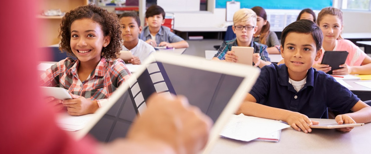 Grundschüler und -schülerinnen mit Tablets