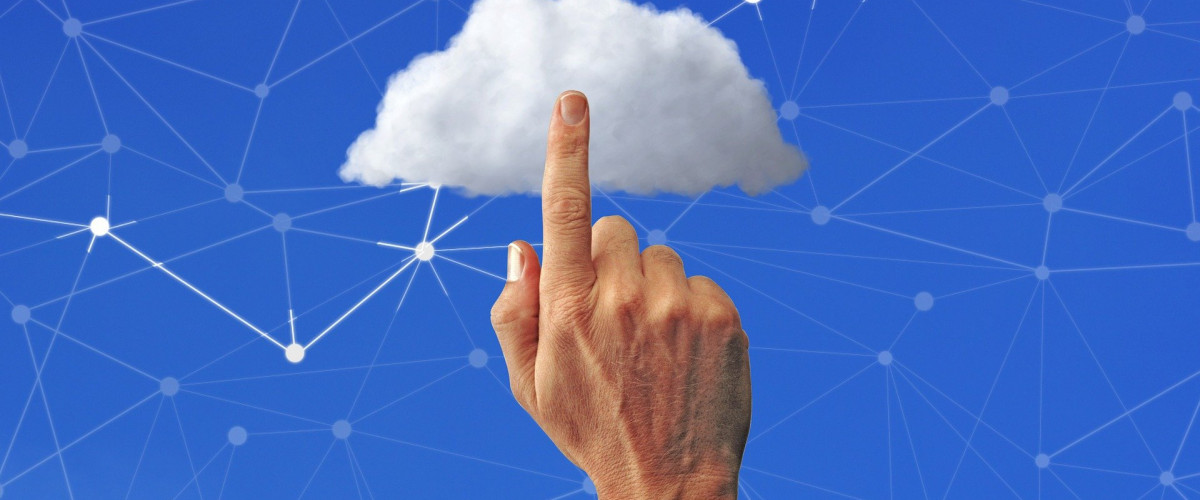 Symbolbild Cloud Computing: Ein Finger tippt auf eine Wolke